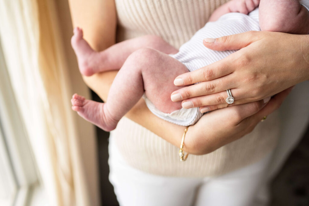 Detail image of mother holding newborn baby in her arms. 